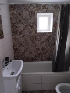 a bathroom with a tub and a sink and a window at Ubytovanie Tibor Skarba in Dunajská Streda