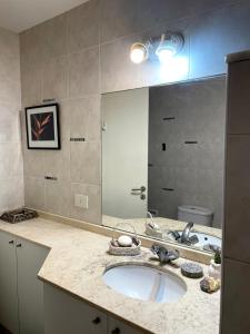 baño con lavabo y espejo grande en Habitación con baño privado Regis Haus en Villa Adelina