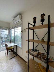 Zimmer mit Regalen, einem Tisch und einem Fenster in der Unterkunft Habitación con baño privado Regis Haus in Villa Adelina