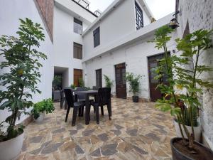 un patio con mesa, sillas y macetas en Lonko Hostel, en Arequipa