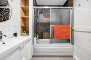a bathroom with a shower with an orange towel at Luxury Delta 2BD Suit on ground floor in Delta