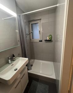 uma casa de banho com uma banheira e um lavatório e uma banheira em Seven Swiss Wonders, City Center em Zürich