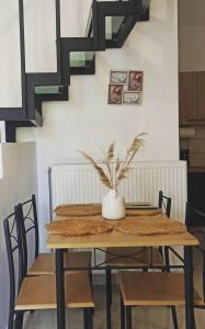 普洛馬里翁的住宿－Io the cosy home Plomari，桌子,椅子和上面的花瓶