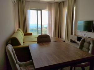 een woonkamer met een tafel, een bank en een televisie bij Skyline View Apt & Pool Retreat in Budva
