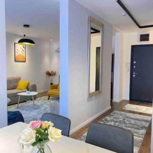 a living room with a table with a vase of flowers at Rita Apartment in the heart of Pristina,Kosovo in Pristina