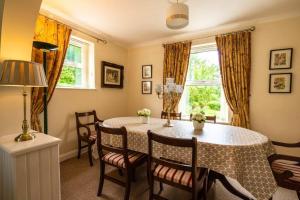 a dining room with a table and chairs and a window at Lime Tree House in Maguires Bridge