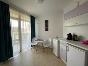 a kitchen with a table and chairs and a window at FREGATA 16 Studio Sveti Vlas in Sveti Vlas