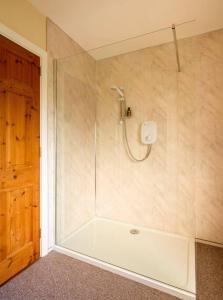 W łazience znajduje się prysznic z białą wanną. w obiekcie Lime Tree House w mieście Maguires Bridge