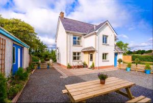 a house with a picnic table in front of it at Lime Tree House in Maguires Bridge