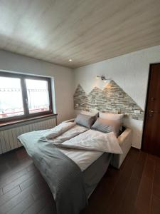 a bedroom with a large bed with a brick wall at Baita PierGi in Livigno