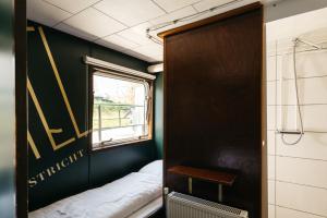 マーストリヒトにあるボテル マーストリヒトのベッドと窓が備わる小さな客室です。