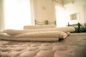 einen Stapel Handtücher auf dem Bett in der Unterkunft LA RESIDENZA DI ADAMO in Syrakus
