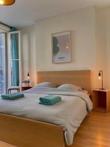 ein Schlafzimmer mit einem großen Bett mit zwei grünen Kissen darauf in der Unterkunft Maï Homes - Le Cœur Canebière in Marseille