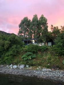 una casa sentada en la cima de una colina junto a un río en Casa Lago Rupanco, en Puerto Rico