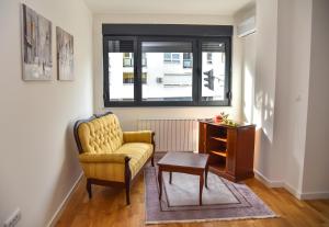 a living room with a yellow chair and a table at Apartment Banja Luka, Park in Banja Luka