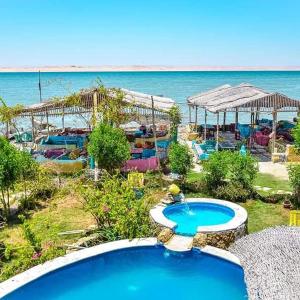a resort with a swimming pool and the ocean at Kamariat Tunis Bay in Kafr ‘Amr