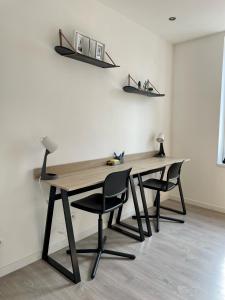einen Holztisch mit zwei Stühlen in einem Zimmer in der Unterkunft Gîte Shaka in Gravelines