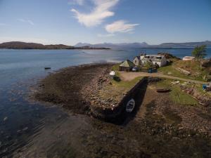 an aerial view of a house on the shore of a lake at Pier Cottage, Applecross in Applecross