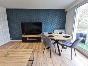 a dining room with a table and a television at L'Inattendu - Les Maisons de Madeleine in Nantes