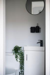 a bathroom with a white sink and a mirror at Debenham Lodge Margate in Kent