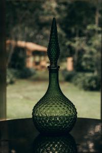 a green glass vase sitting on top of a table at Cabaña en cafetal de Coatepec in Coatepec