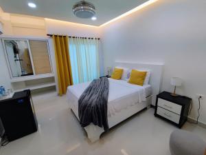 1 dormitorio con 1 cama con almohadas amarillas y TV en Hotel el barco en Azua de Compostela