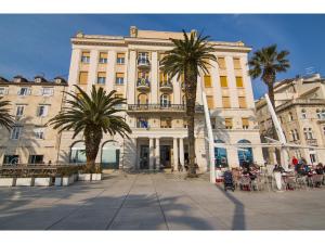 un gran edificio con palmeras delante en Riva Royal View Luxury Apartments, en Split