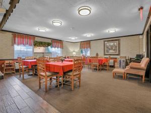 a dining room with red tables and chairs at Red Roof Inn Uhrichsville in Uhrichsville