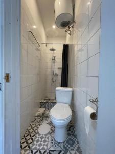 a bathroom with a toilet and a tiled floor at Cozy 1bedroom condo near Baltic sea in Salacgrīva