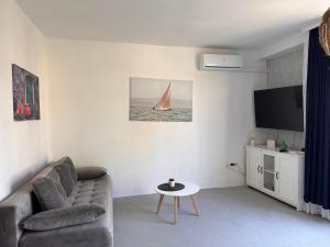 - un salon avec un canapé et un voilier sur le mur dans l'établissement Beach Apartment, à Biograd na Moru