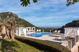a villa with a swimming pool and a mountain at Finca Albellons in Binibona