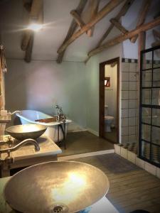 een grote badkamer met een wastafel en een bad bij Mill Lane Farmhouse in Hartbeespoort