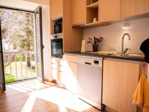 a kitchen with a sink and an open door at Les gites de Sylvie in Ussat