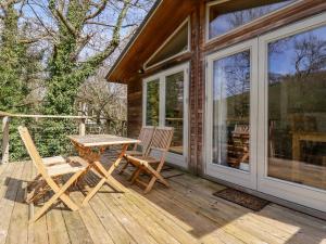 a wooden deck with a table and two chairs at 7 Stonerush Valley in Looe