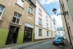 a car parked on a cobblestone street next to buildings at Heart of Center in Rzeszów
