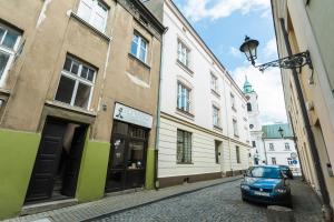 un coche aparcado en una calle empedrada junto a los edificios en Heart of Center, en Rzeszów