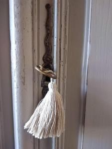 a tassel attached to a door with a whisk at Gîte Brilhac in Monts-sur-Guesnes