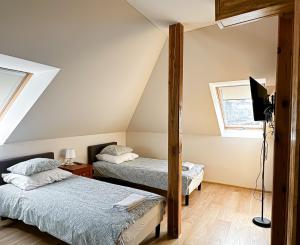 a attic bedroom with two beds and a mirror at Pokoje na Jasełkowej in Szczecin