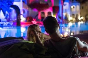 a man and a woman sitting next to a pool at Sotavento Beach Club in Costa Calma
