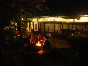 a group of people sitting around a fire at night at fumoku - Vacation STAY 12915v in Chino