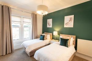 2 letti in una camera con pareti verdi di 3 Bedroom villa attached to Host home free parking a Perth