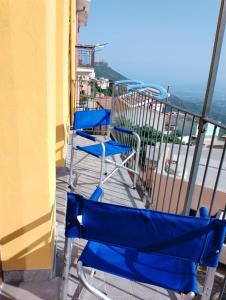 un paio di sedie blu sedute su un balcone di Sa Dommu de Kerciu vista mare IUN R0018 a Baunei
