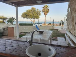 un fregadero en un patio con una mesa y la playa en san lorenzo a 4 mt dal mare colore smeraldo a due passi da Marzamemi, en Reitani