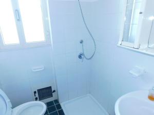 y baño blanco con ducha y aseo. en Appartamento San Carlo, Condofuri (RC), en Condofuri Marina