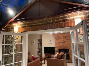 a living room with a brick wall and a fireplace at Holly Lodge in Norwich