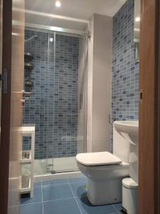 a bathroom with a toilet and a glass shower at Piso en Cedeira in Cedeira