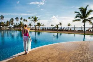 a woman standing in front of a swimming pool at Nickelodeon Hotels & Resorts Punta Cana - Gourmet All Inclusive by Karisma in Punta Cana