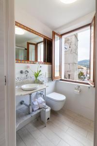 a bathroom with a sink and a toilet and a window at Sirolo Sea rooms in Sirolo