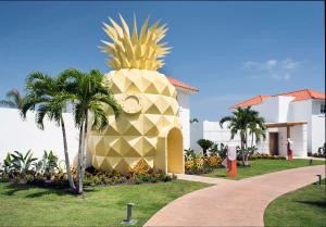 a pineapple shaped building with palm trees in front of a building at Nickelodeon Hotels & Resorts Punta Cana - Gourmet All Inclusive by Karisma in Punta Cana