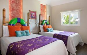two beds in a room with purple and orange at Nickelodeon Hotels & Resorts Punta Cana - Gourmet All Inclusive by Karisma in Punta Cana +37 photos